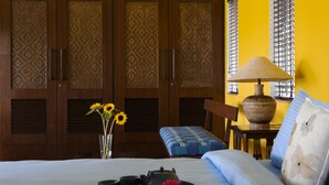 Een slaapkamer met een bed, nachtkastje en een raam met zonwering.