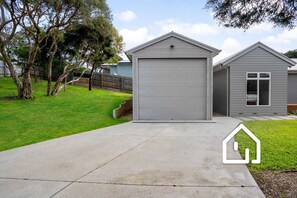 Stroll through the well-manicured lawn to the single-story house with a garage door.