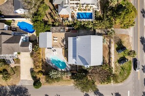 Ein Luftbild eines Wohnhauses mit Schwimmbad, überdachter Terrasse und großer Garage.
