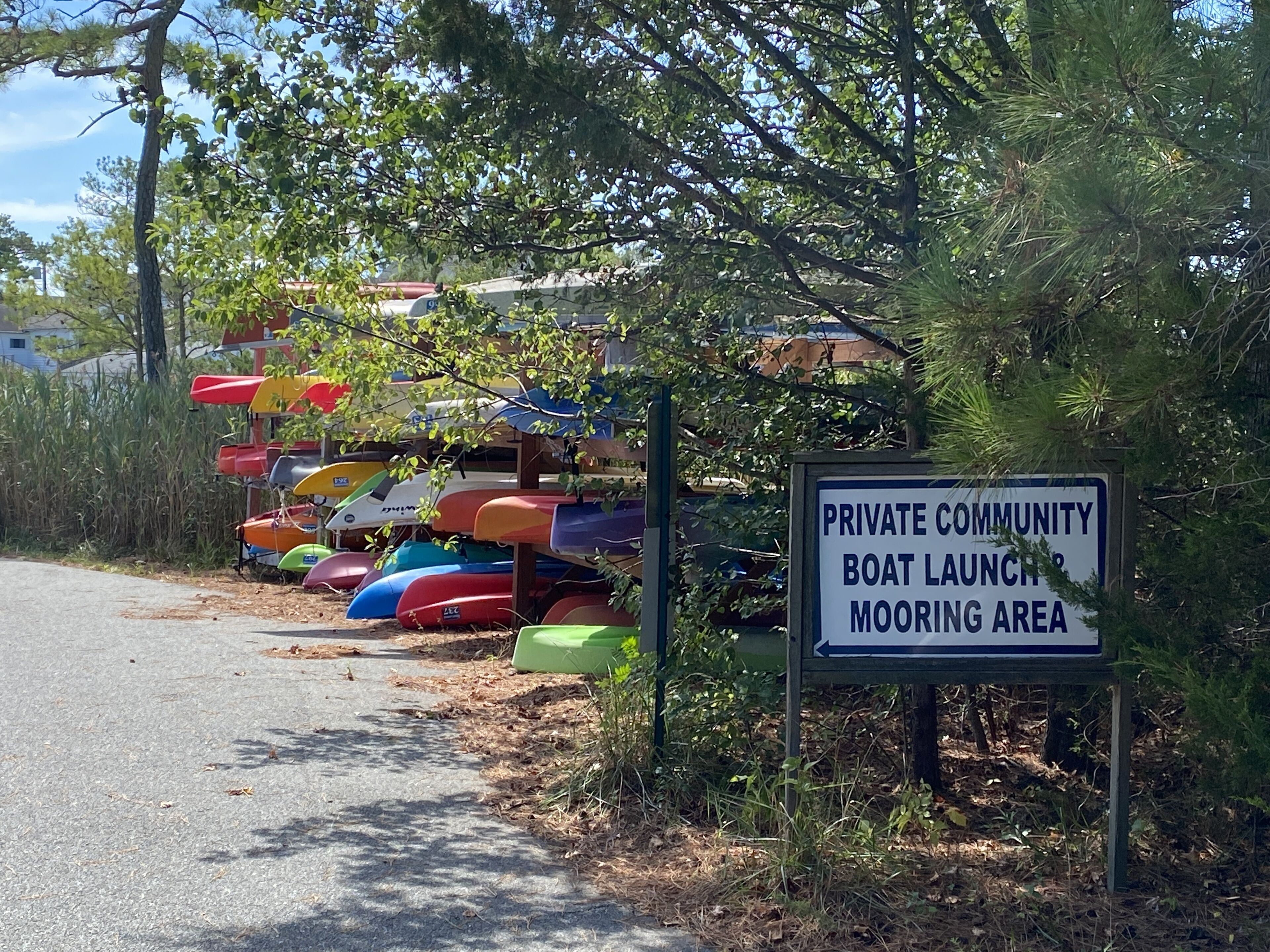 A private community boat launch mooring area with colorful kayaks and canoes.