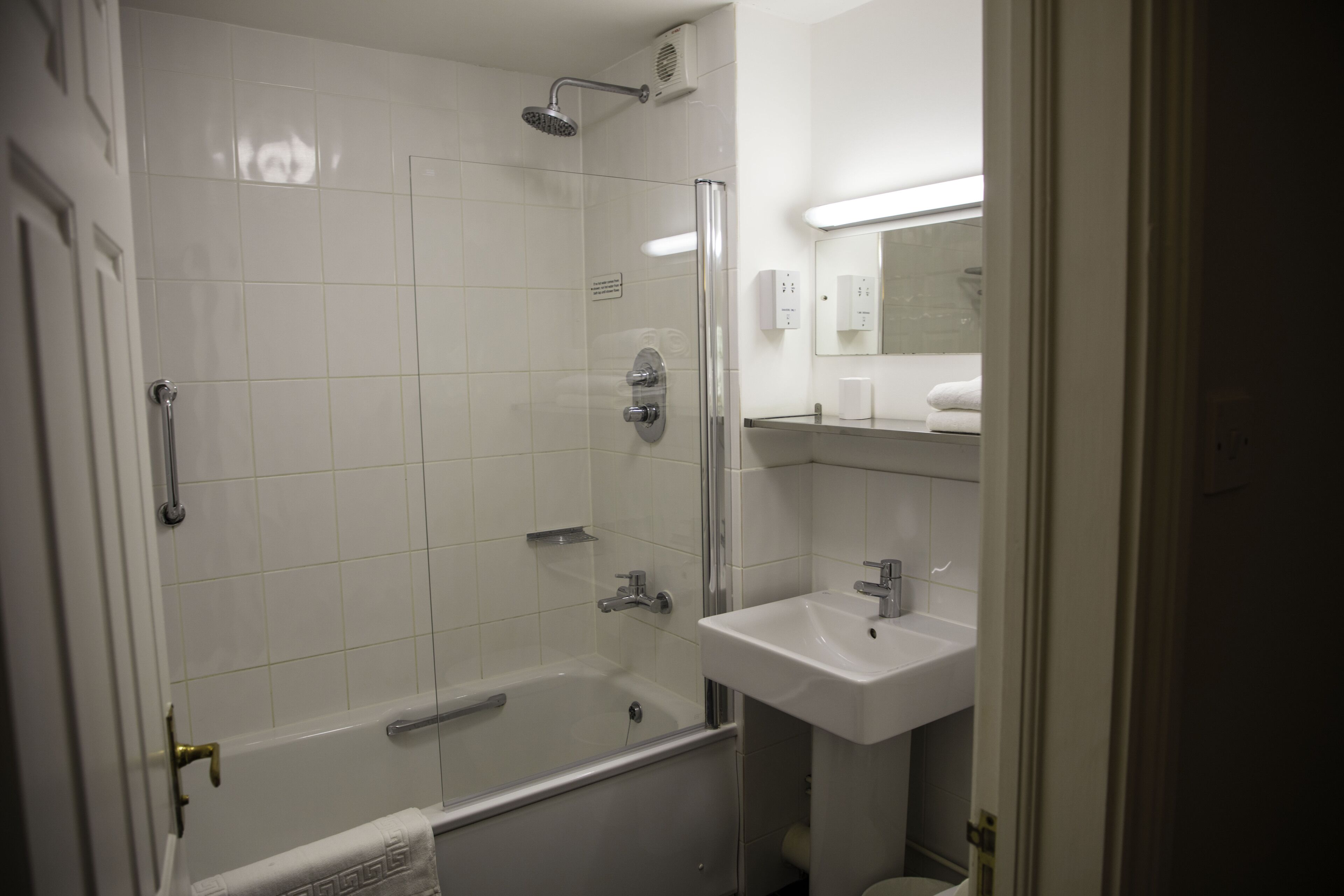 A bathroom with a bathtub, shower, and sink.