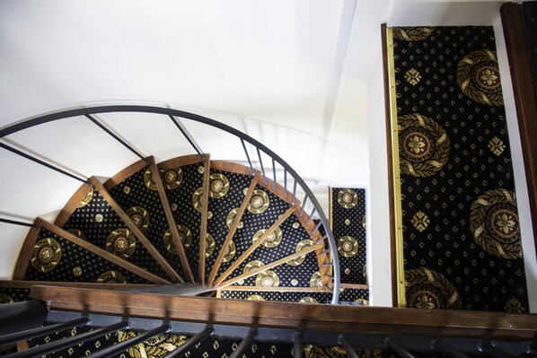 A spiral staircase with a black and gold patterned carpet. - The Charlton Boutique Hotel (Cheltenham)