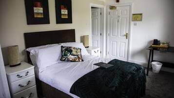 A neatly arranged bedroom with a bed, bedside tables, and a nightstand.