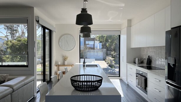 A modern kitchen with a central island, a large window, and a view of the outdoors. - Luxury on Bayview Wifi Linen included (Inverloch)