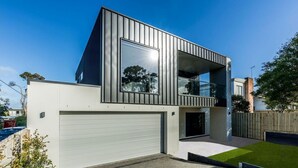 A modern two-story house with a garage, large windows, and a balcony. - Luxury on Bayview Wifi Linen included (Inverloch)