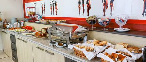 A buffet setup with various food items and condiments.