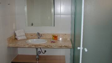 Un baño con lavabo, espejo y perchero para toallas.