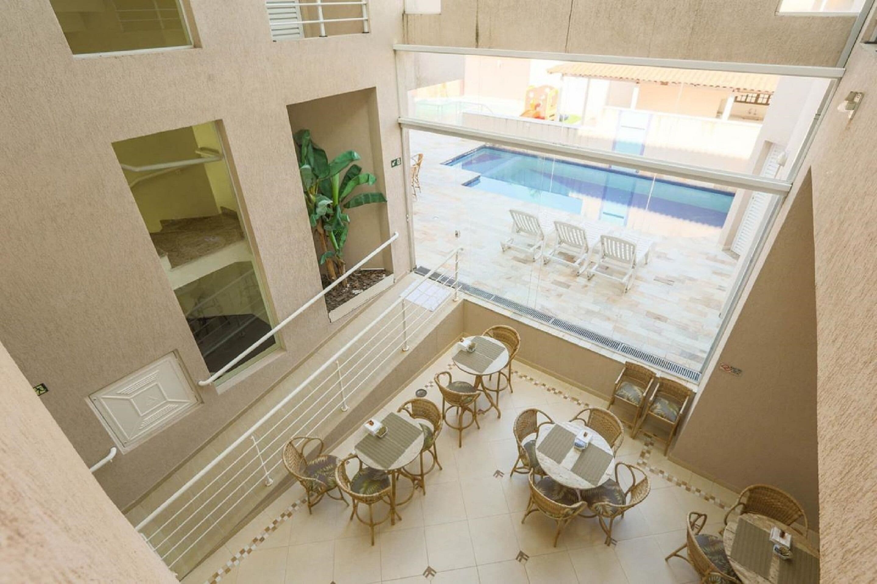A balcony with wicker furniture, a pool, and a view of the pool area.