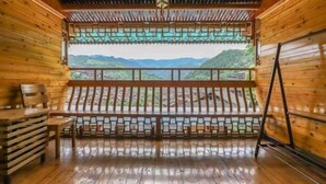 Une cabane en bois dotée d’un balcon donnant sur un paysage montagneux.