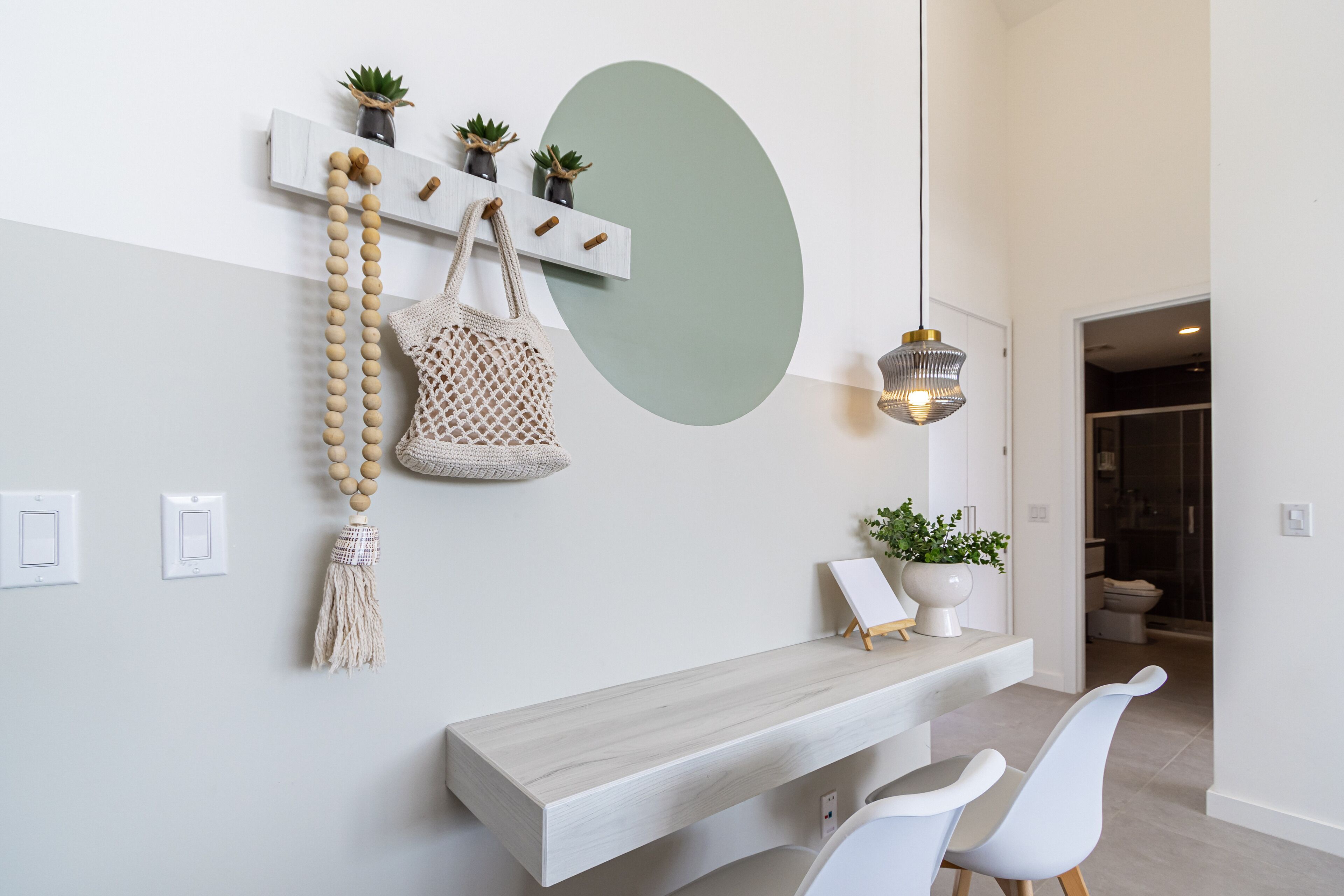 A modern interior with a wooden bench, a wall-mounted shelf with plants, and a minimalist design.