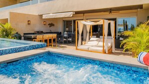 A modern outdoor pool area with a hot tub, a covered seating area, and a dining setup.