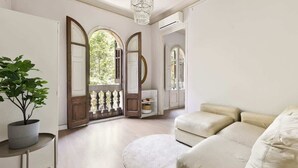 Een ruime woonkamer met een grote beige bank, een rond tapijt en een potplant.