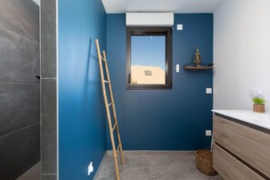 A bathroom with dark blue walls, a wooden ladder, a window, a shelf with a plant, and a wooden cabinet. - Villa Lion | Private Spa, Pool/Jacuzzi, Terrace, Arcade (Ittenheim)