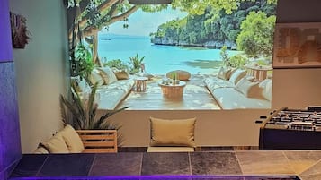 A modern indoor pool area with a large window overlooking a tropical landscape.