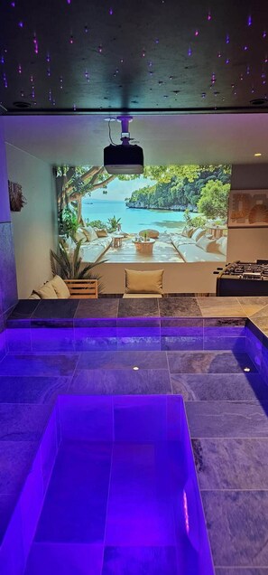 A modern indoor pool area with a large window overlooking a tropical landscape. - Villa Lion | Private spa, pool/hot tub, terrace, arcade (Ittenheim)