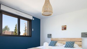 A bedroom with a bed, a window, and a hanging light fixture. - Villa Lion | Private Spa, Pool/Jacuzzi, Terrace, Arcade (Ittenheim)
