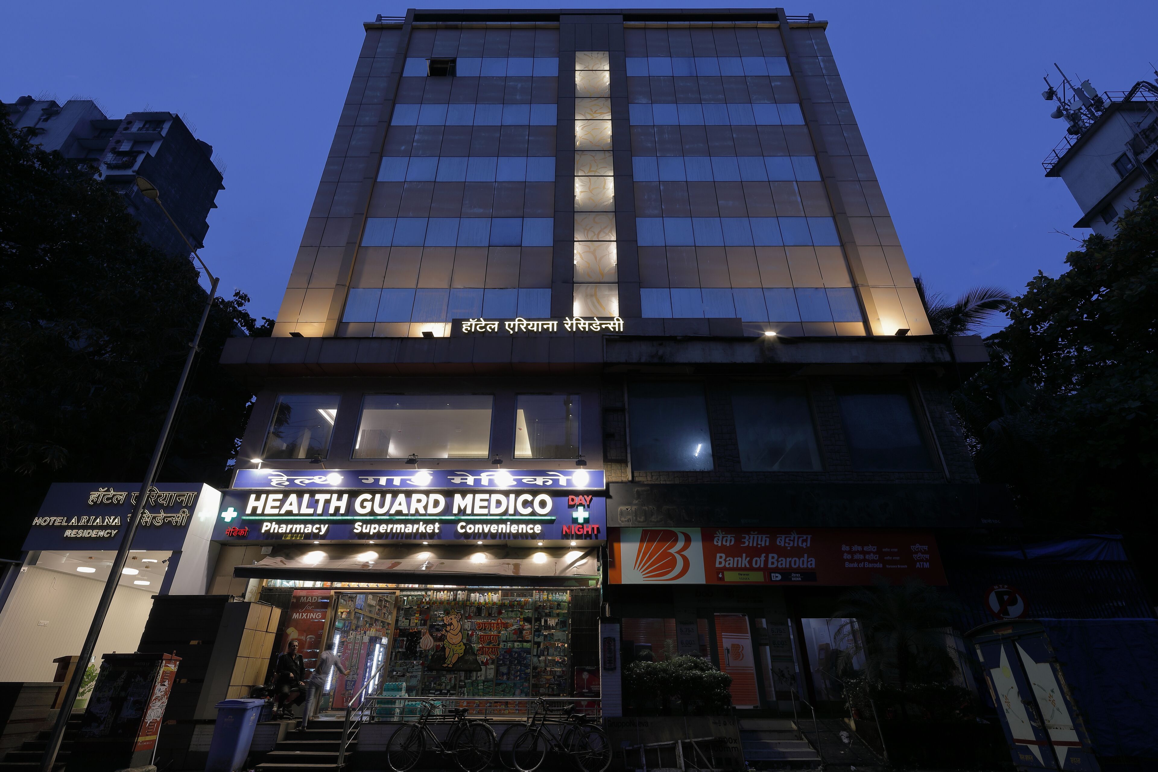 A multi-story building with a pharmacy and a hotel named "Hotel Ariyana Residency" at the ground level.