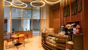 Ein modernes Restaurant mit Holzinnenraum, einer Bar und einem Buffet mit verschiedenen Speisen.