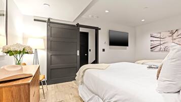 A modern bedroom with a sliding door, a flat-screen TV, and a minimalist decor.