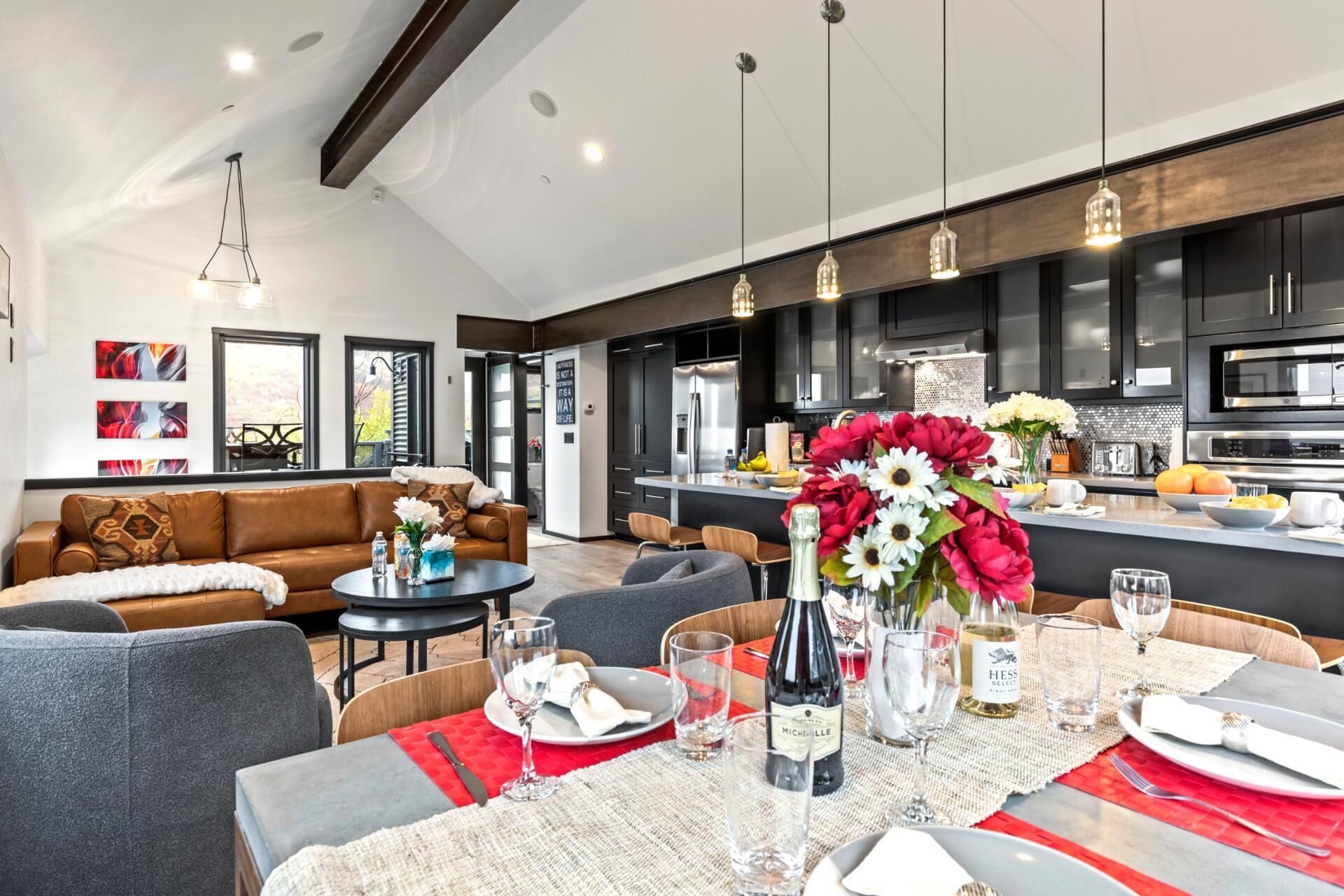A modern kitchen with black cabinets, stainless steel appliances, and a central island.