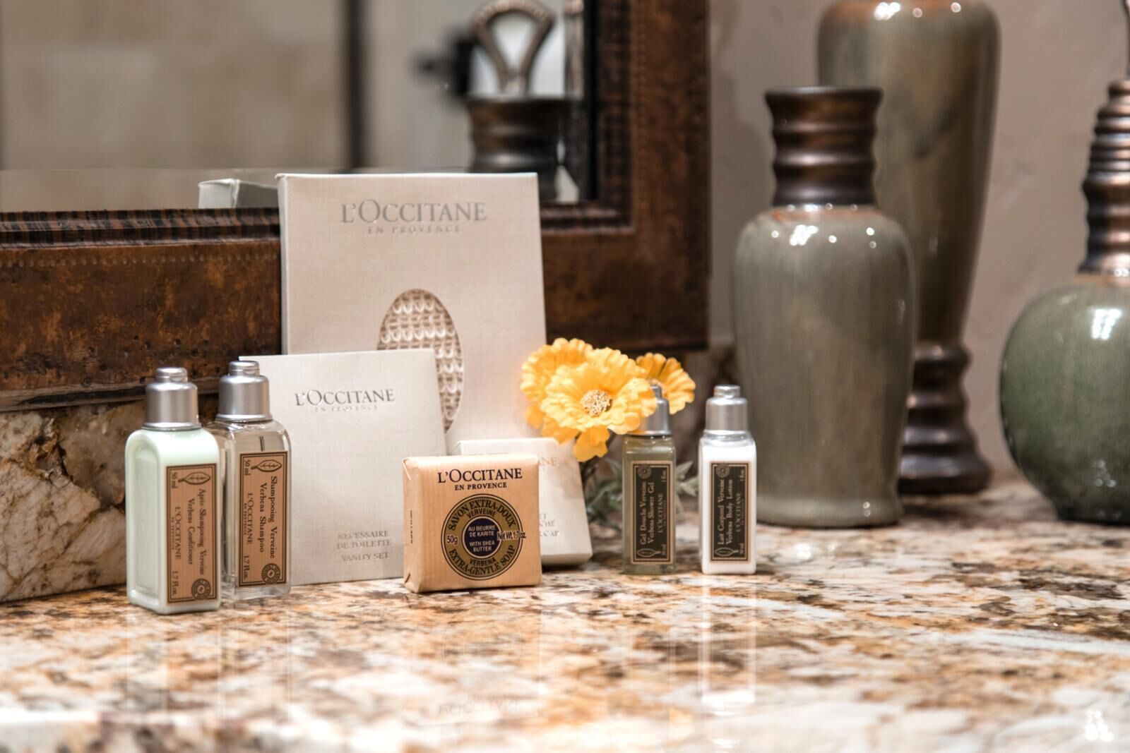 A bathroom vanity with toiletries, a mirror, and decorative vases.