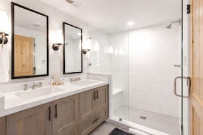 A bathroom with two sinks, a shower, and wooden cabinets. - Empire Avenue Townhomes by KBM (Park City)