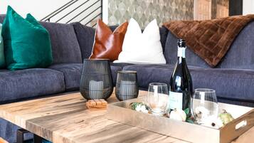 A wooden coffee table with a tray holding a bottle of wine, glasses, and decorative items.