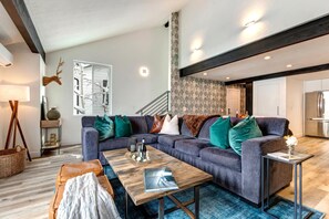 A modern living room with a grey sectional sofa, a wooden coffee table, and a blue carpet. - Aspen Grove 3 Bedrooms AGC-8 by KBM (Park City)