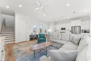 Stylish living space with a staircase, seating area, dining table, and kitchen.
