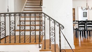A staircase with ornate black railings leading to a second floor. - Historic Midtown Chateau + Guest House - Minutes from Everything (Memphis)