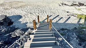 A wooden staircase leading to a beach with clear turquoise water and a clear sky. - Luxury beachfront home, Heated private pool, Five King suites w/ ensuite baths! (Georgetown)