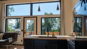 Una cocina moderna con ventanas amplias, una zona de comedor y un sofá.