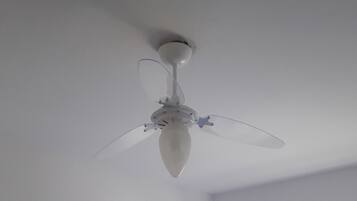 Un ventilador de techo con tres aspas y una lámpara central.