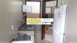 A compact kitchen with a gas stove, a built-in oven, and a refrigerator. - Cabo Frio Parque Burle Aluguel Economico (Cabo Frio)