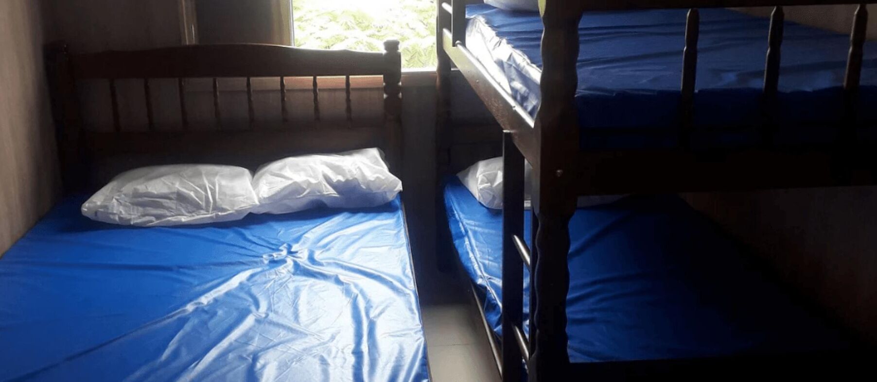 A bunk bed with blue bedding and white pillows.