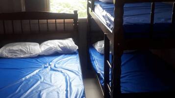 A bunk bed with blue bedding and white pillows.