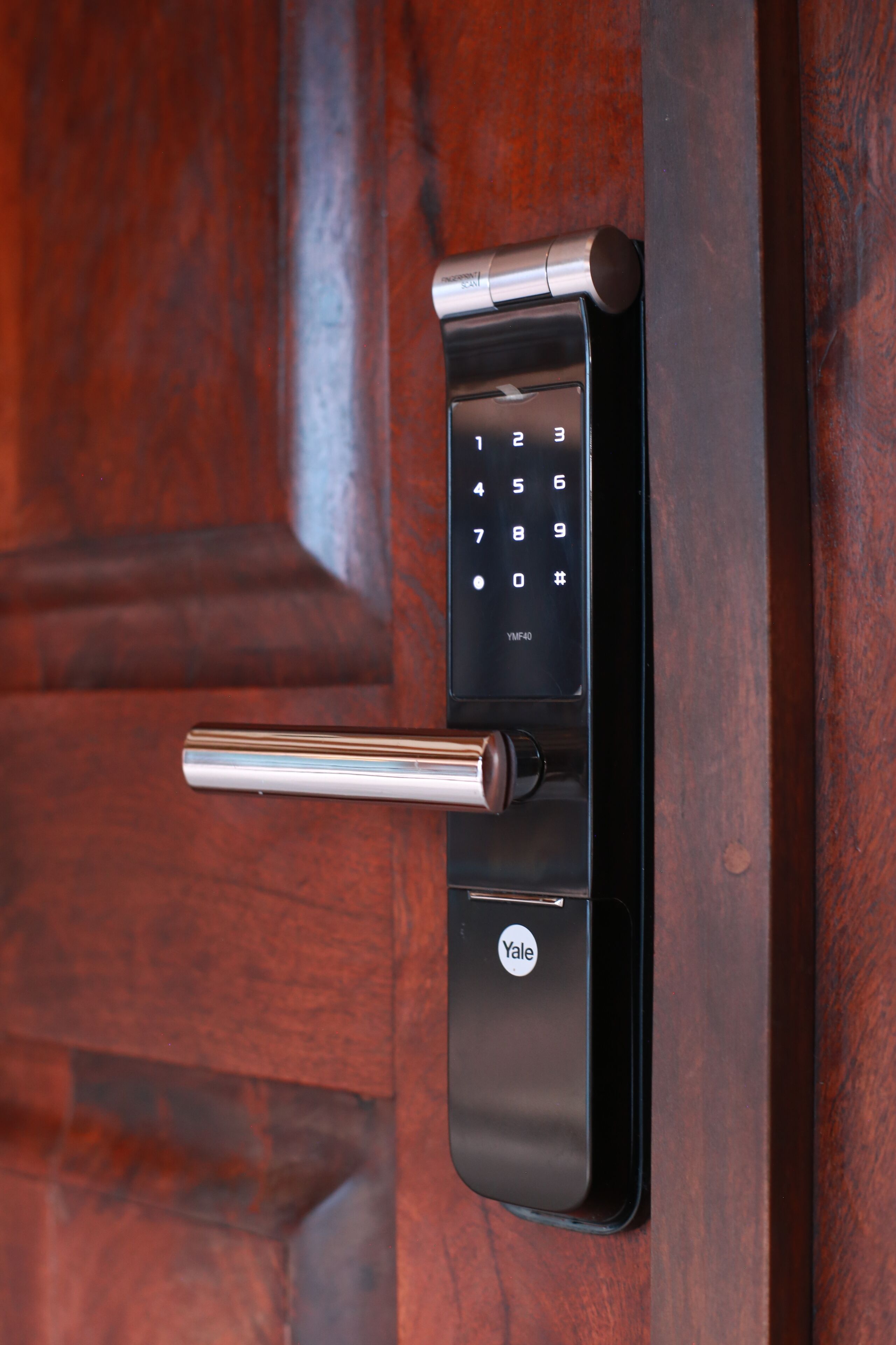 A Yale smart lock on a wooden door.