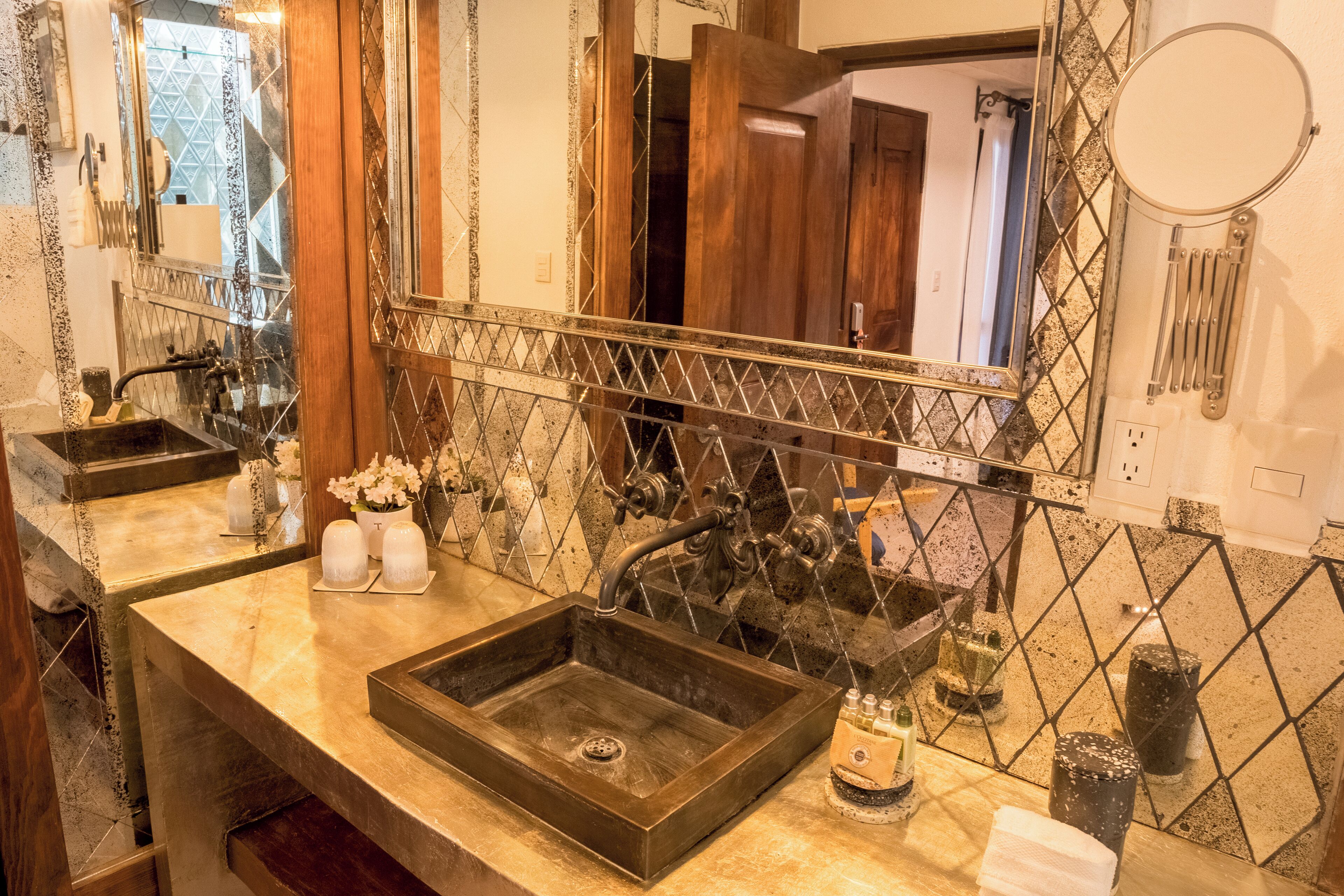Un baño con un espejo grande, un lavabo y una zona de ducha.