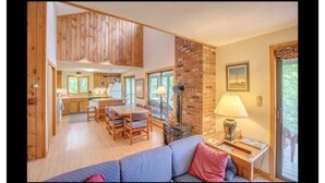 A cozy living room with a sofa, a dining table, and a fireplace. - My Mountainside Mansion in Waterville Estates!🏔☀️🏊‍♀️⛷ (Campton)
