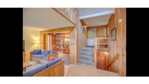 A wooden interior with a sofa, a bookshelf, and a staircase. - My Mountainside Mansion in Waterville Estates!🏔☀️🏊‍♀️⛷ (Campton)