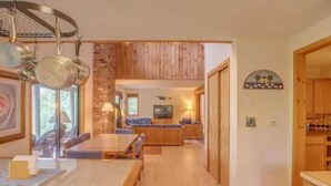 A cozy interior with a dining area, a living room with a sofa and TV, and a kitchen with wooden cabinets. - My Mountainside Mansion in Waterville Estates!🏔☀️🏊‍♀️⛷ (Campton)