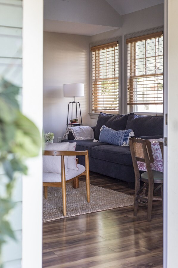 A cozy living room with a dark blue sofa, a wooden coffee table, and a lamp.