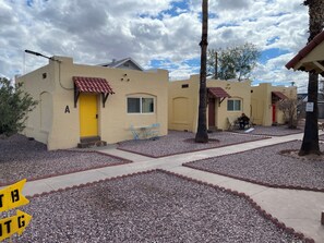 Residential-style buildings with flat roofs and stucco walls, each with a distinct entrance.