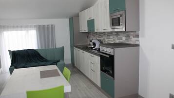 Una cucina moderna con forno a microonde, forno e lavello. C'è una zona pranzo con tavolo e sedie.