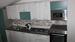 Eine moderne Küche mit Gasherd, Mikrowelle und Kaffeemaschine.