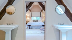 A bedroom with a large bed, two bedside tables, and a window.