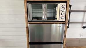Una cocina con refrigerador de acero inoxidable y horno tostador empotrado.