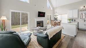 Amplia sala de estar con chimenea, zona de comedor y cocina.