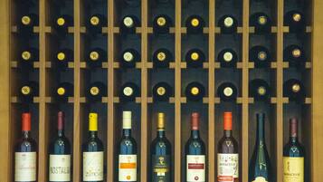 Una estantería para vinos con botellas de diferentes tipos, incluyendo marcas como 'Nostalgia' y 'Kovacevic'.