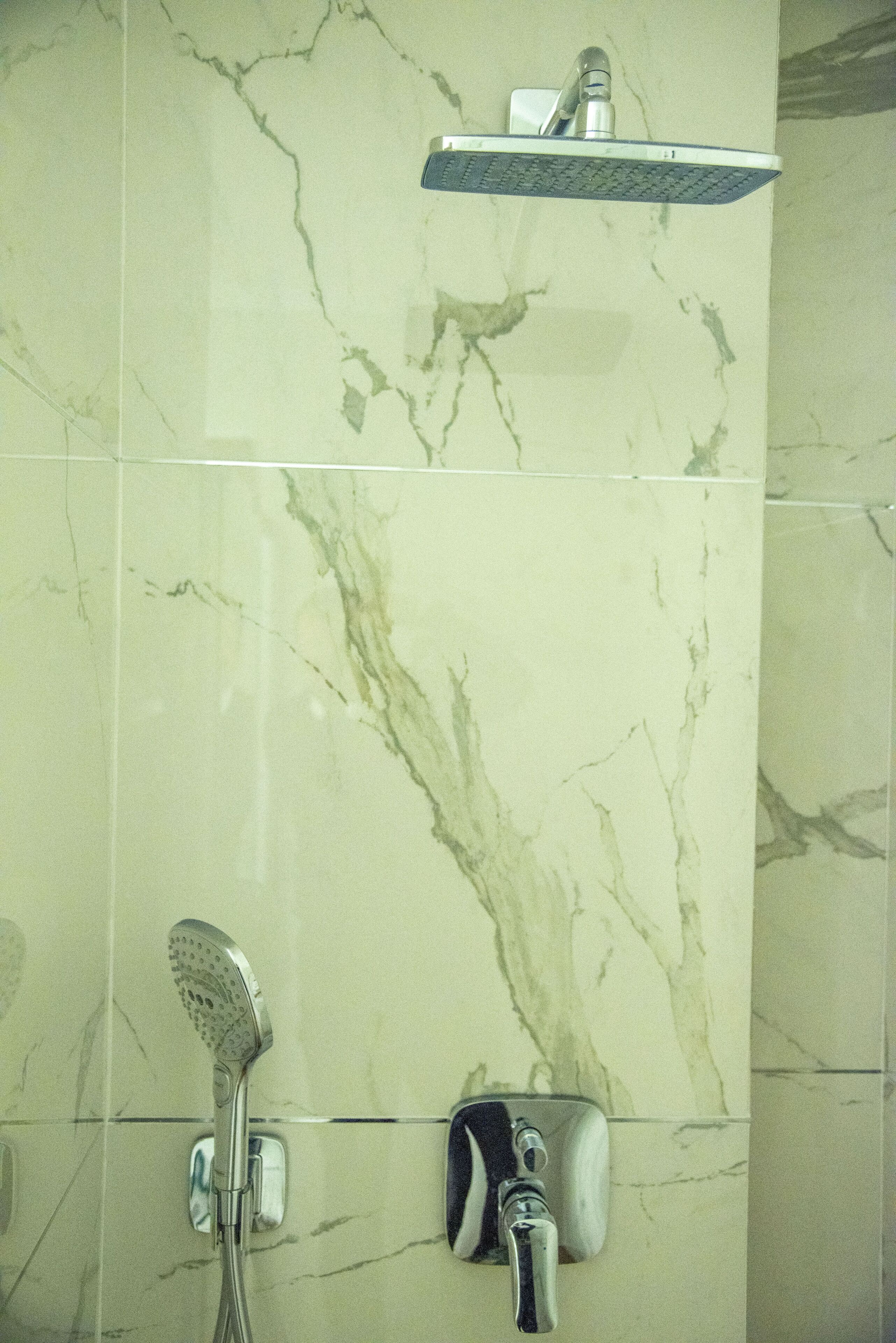 Ein Badezimmer mit Dusche, Duschbrause und Wandarmatur.